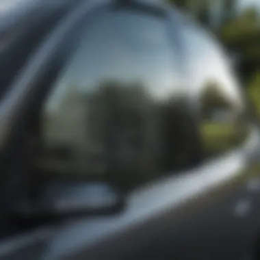 Applying glass cleaner to tinted car window with a microfiber cloth