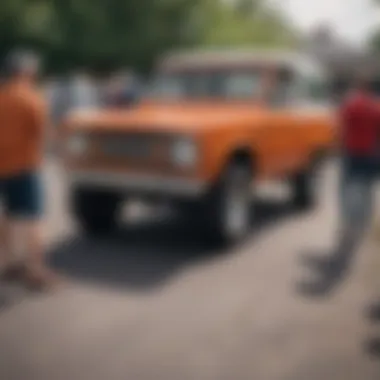 A group of enthusiasts admiring a collection of restored Broncos at a car show