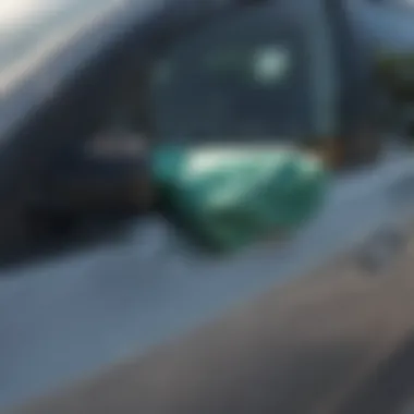 Close-up of a microfiber cloth cleaning a car window with sunlight reflecting off the glass